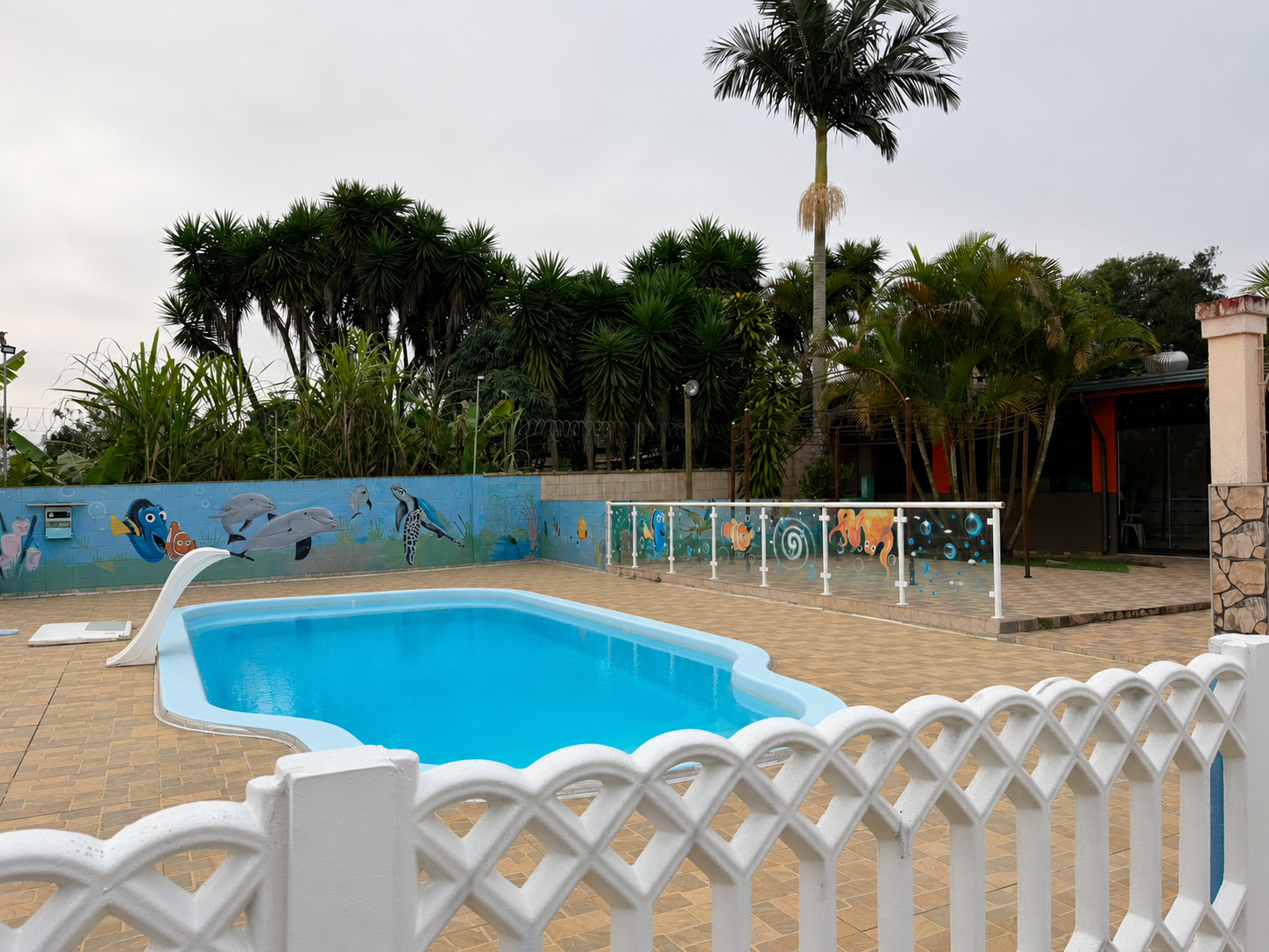 Piscina com escorregador e mural do fundo do mar